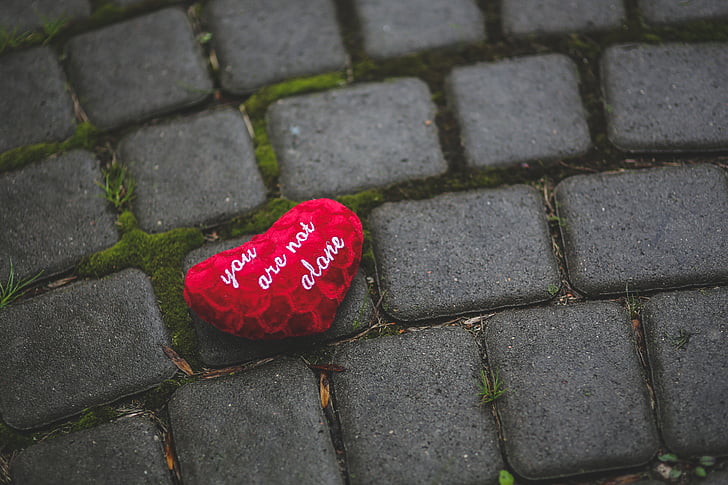 photo of red heart with text on gray pavement