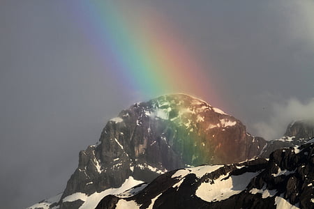 gray rock formation and rainbow