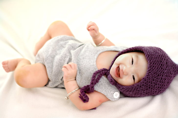 baby wearing purple aviator hat