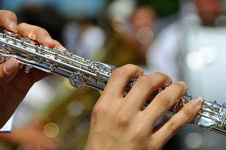person playing silver flute