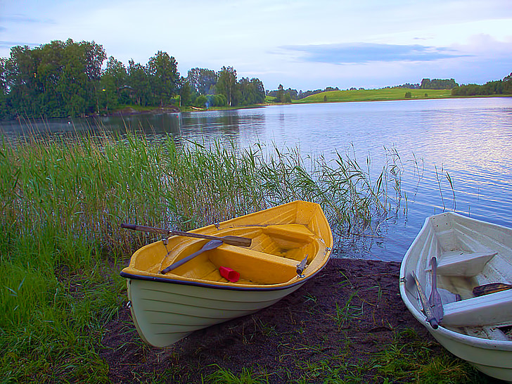 canoe beside green grass near body of water