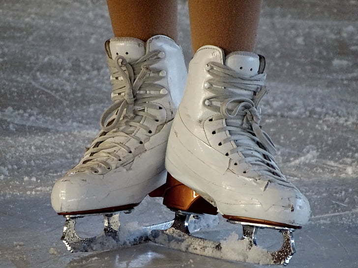 person wearing white figure skates