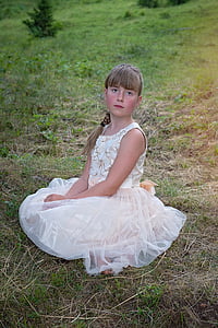 girl wearing white dress sitting on grass