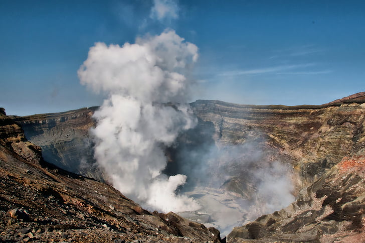 volcanic crater spews white smoke