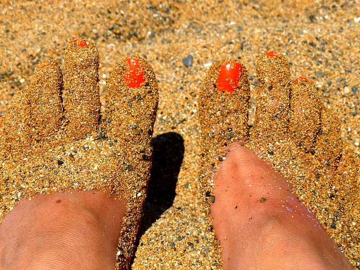 human feet covered with sand