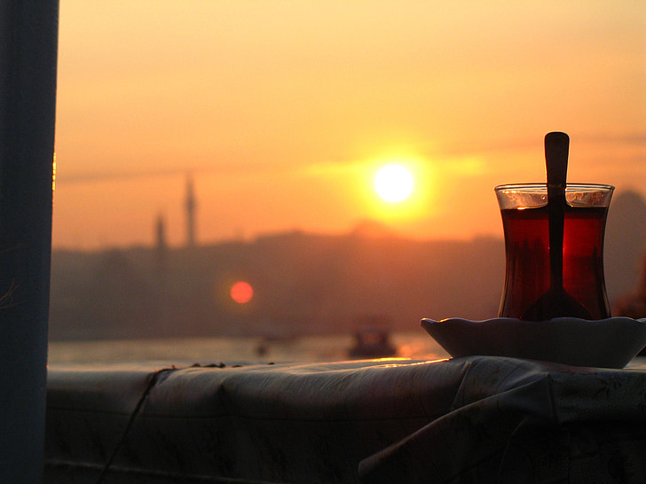 Turkish tea glass on top of saucer facing golden hour