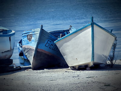 two white and blue boats near seashore