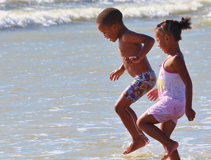 girl and boy playing on beach