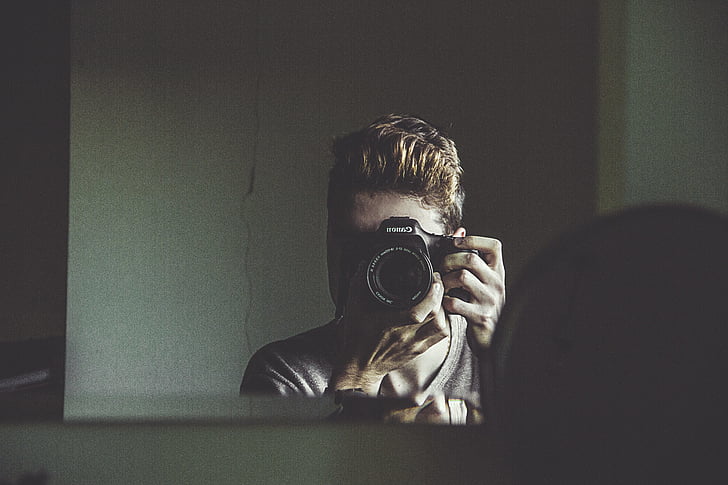 man taking photo of mirror
