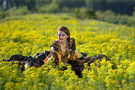 shallow focus photography of woman in yellow rapeseed flower field