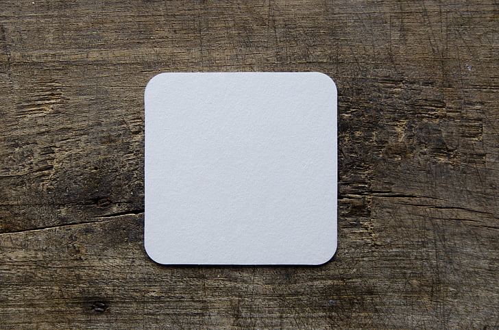square white card on brown wood board panel
