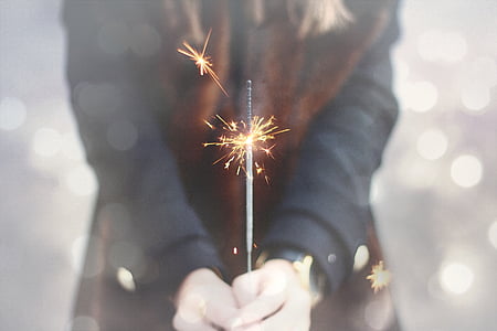 person holding lighted firecracker
