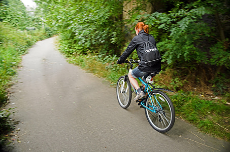 main in black jacket riding in blue mountain bike
