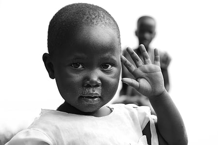 grayscale photo of toddler raising left hand