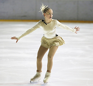 girl wearing white long-sleeved mini dress while in figure skates