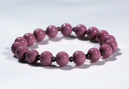 beaded purple bracelet on white surface
