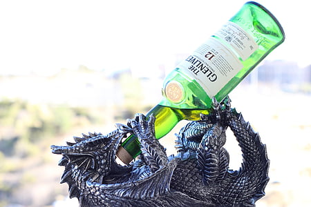 gray dragon bottle holder with green translucent glass beverage bottle