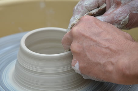 person making clay pot