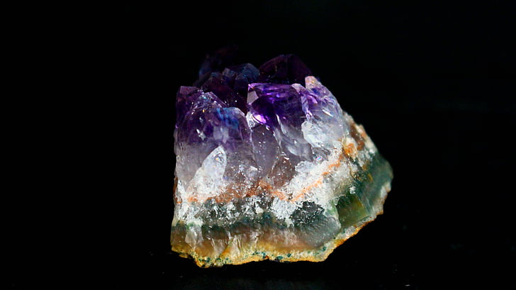 green, white, and purple stone with black background