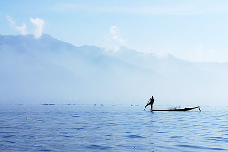 silhouette photography of person on canoe holding oar