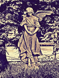 statue of angle near green leaf plants