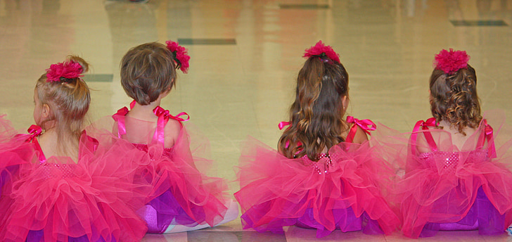 photo of four girls wearing pink ball gowns