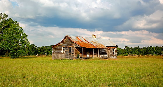 photo of brown wooden house in the middle of land
