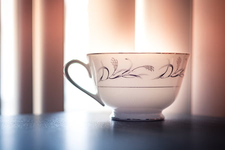 white and black ceramic teacup