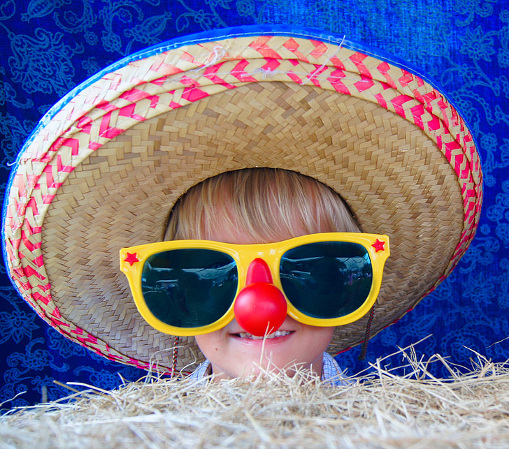 child wearing brown sombrero and yellow sunglasses