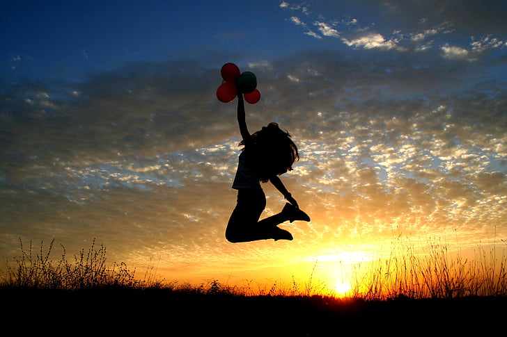 photo of woman jumping on air during golden hour
