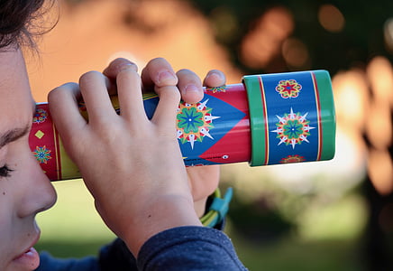 boy holding red and blue scope toy