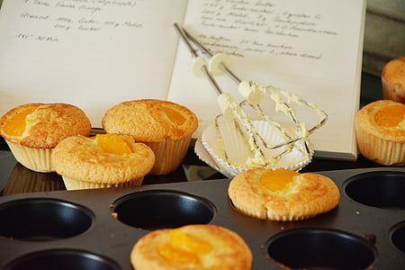 cupcakes beside book and muffin tin