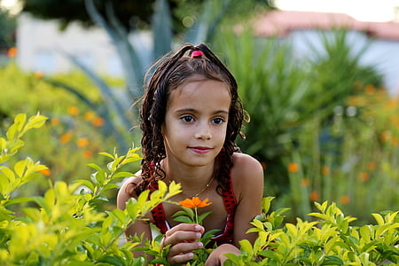 girl holding orange petaled flower