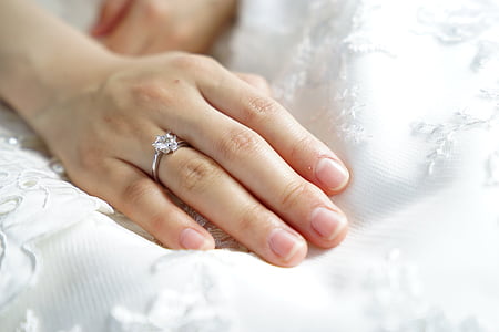 person wearing silver-colored clear gemstone ring