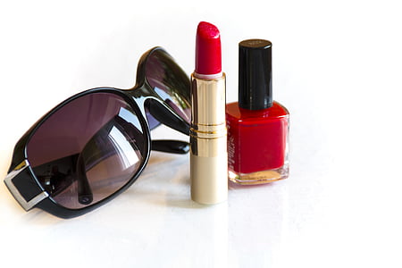women's black sunglasses, red lipstick and red nail polish bottle