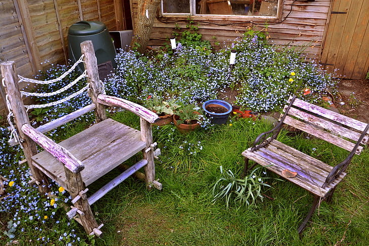 two brown wooden armchairs on garden