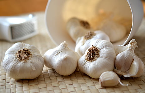 bulbs of garlic on brown woven mat