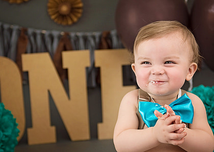 baby wearing brown top with blue bow tie accent