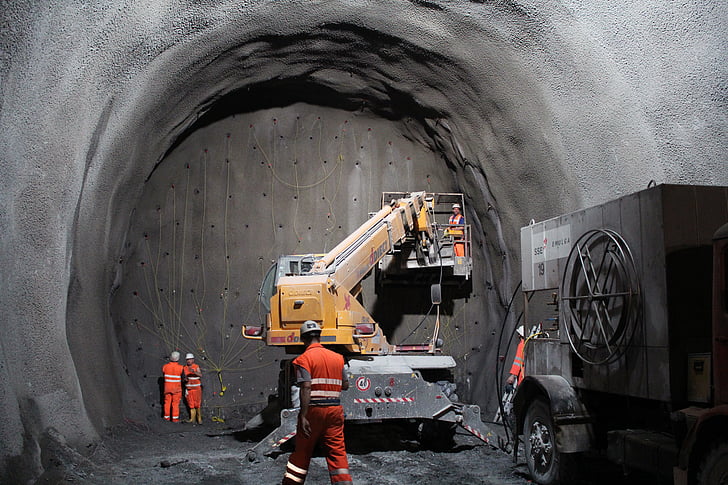 yellow and gray heavy equipment with lift in gray cave