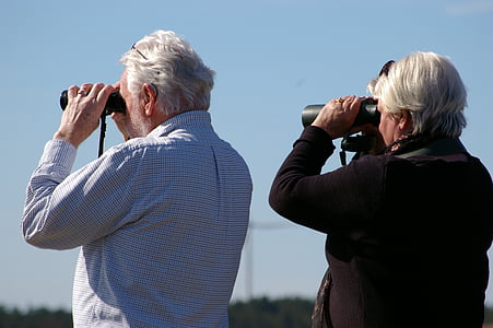 woman and man looking using binoculars