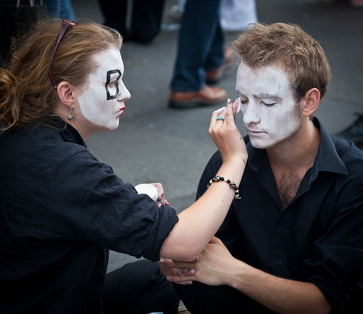 woman doing makeup on man