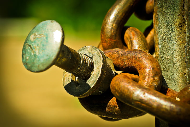close-up photo of brass chain link and bolt