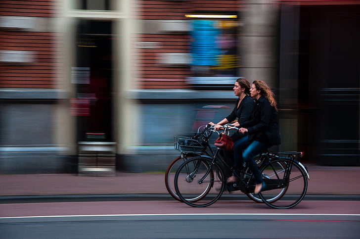 panning photography of two women cycling