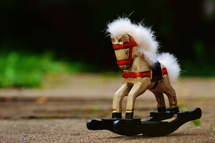 selective focus photography of brown and black toy rocking horse