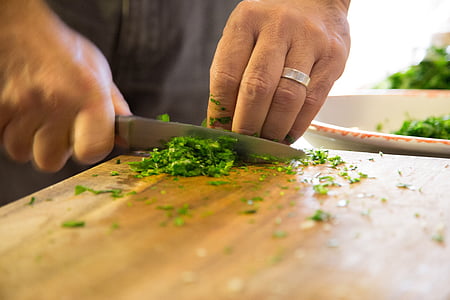 person chopping vegetable using gray knife