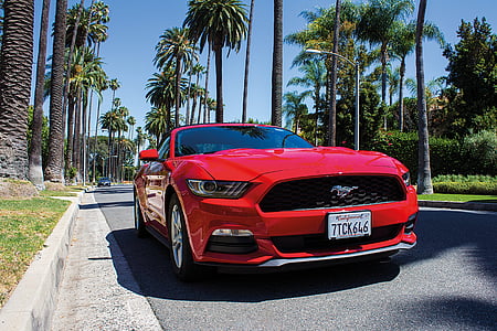 red Ford Mustang coupe on road at daytime