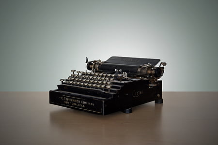 black typewriter on brown surface wallpaper