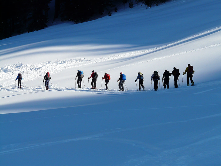 several people walking on snow mountain