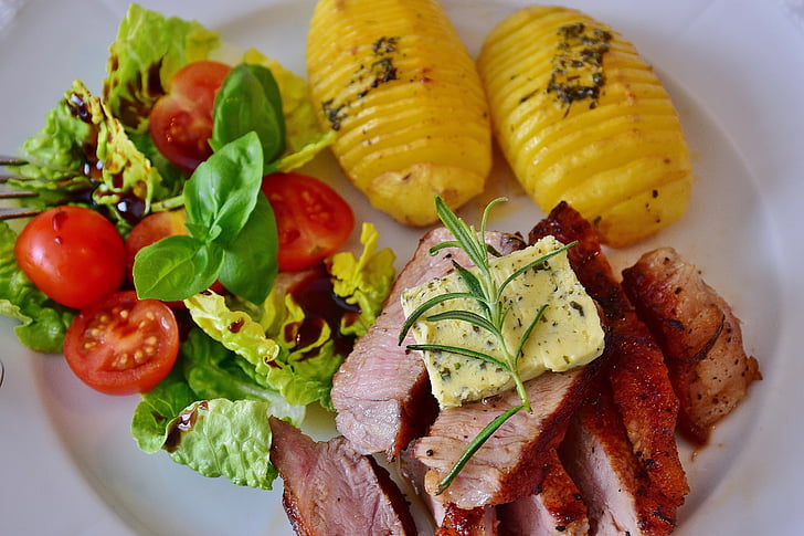 grilled meat ; yellow sliced cheese . two yellow slice pineapples on round white ceramic plate