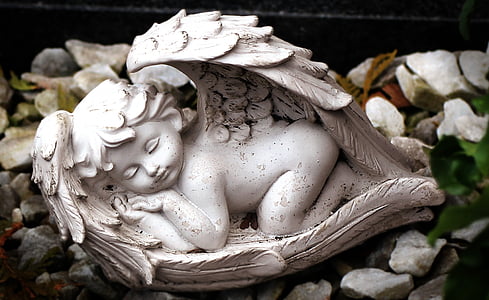 close up photography of sleeping baby angel figurine